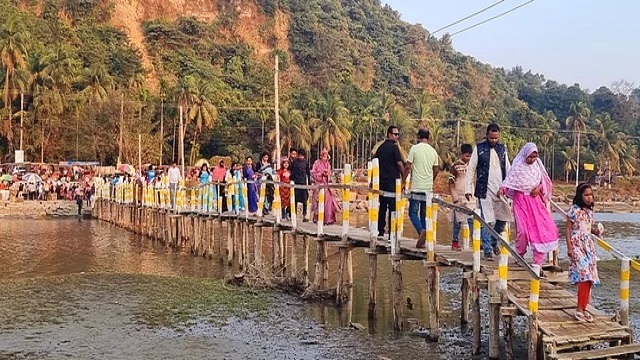কক্সবাজার-টেকনাফ মেরিন ড্রাইভের পাশ দিয়ে কাঠের সাঁকো পার হয়ে প্যাঁচারদ্বীপ সৈকতে ছুটছেন পর্যটকেরা