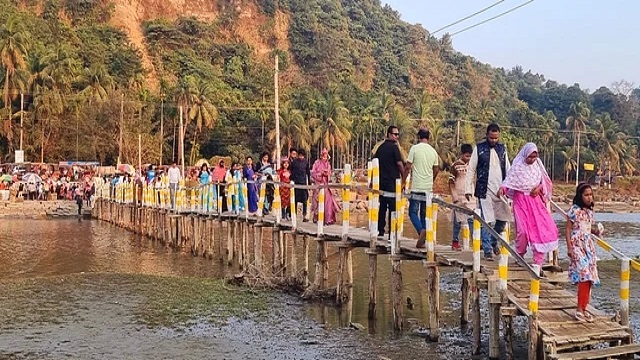 কক্সবাজার-টেকনাফ মেরিন ড্রাইভের পাশ দিয়ে কাঠের সাঁকো পার হয়ে প্যাঁচারদ্বীপ সৈকতে ছুটছেন পর্যটকেরা